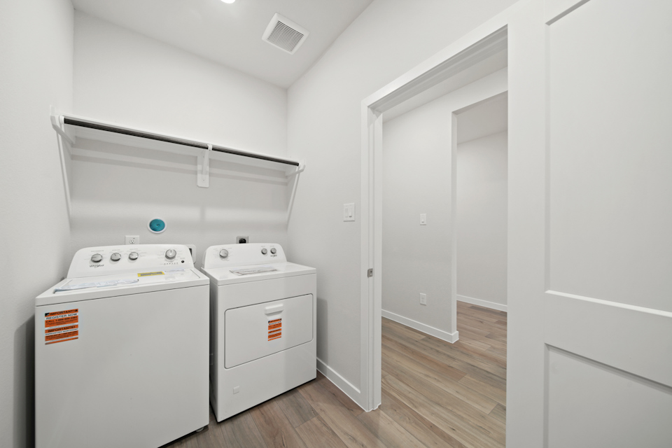 A room with white cabinets and appliances.