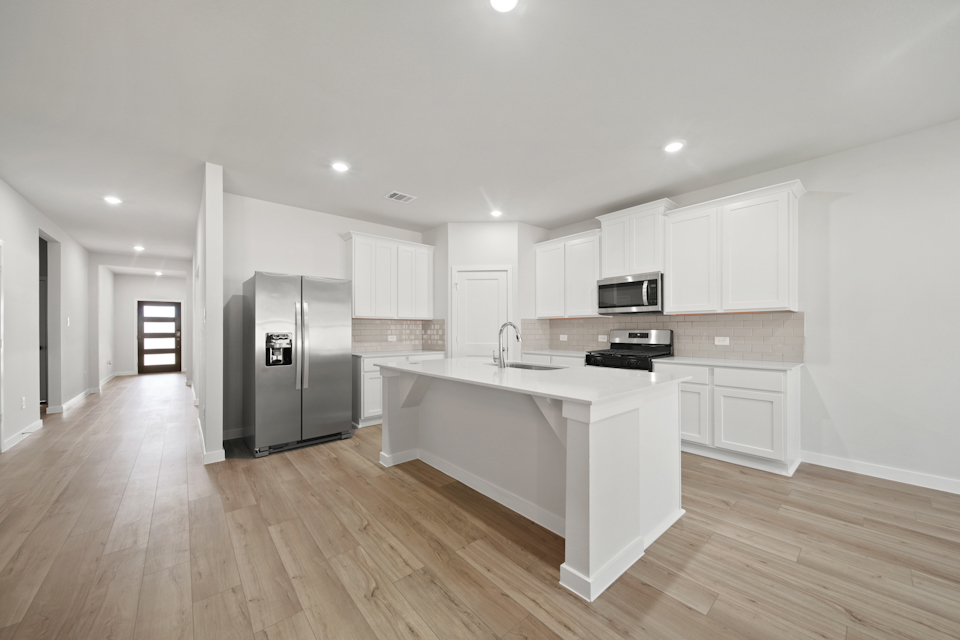 A kitchen with white cabinets.