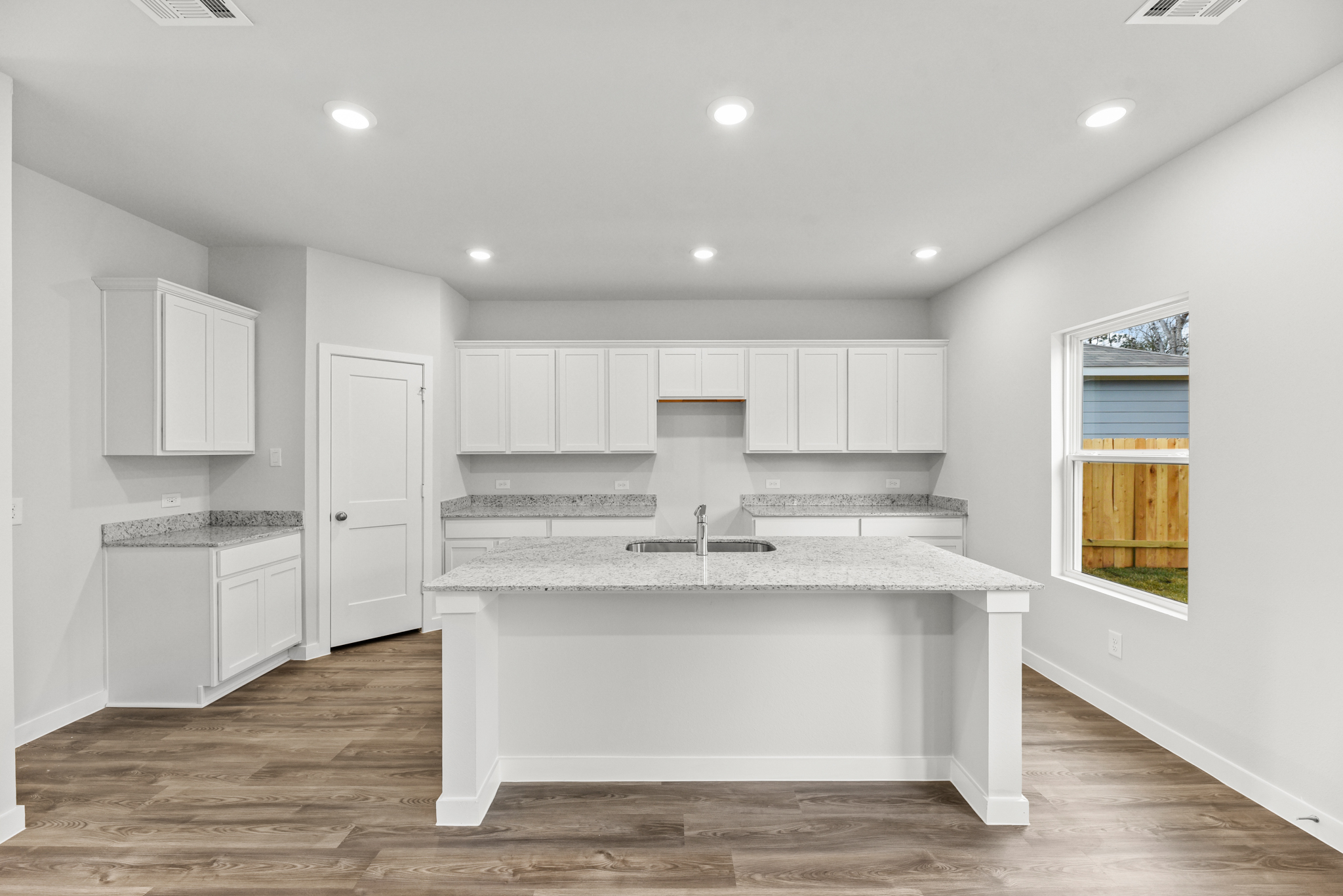 A kitchen with white cabinets.