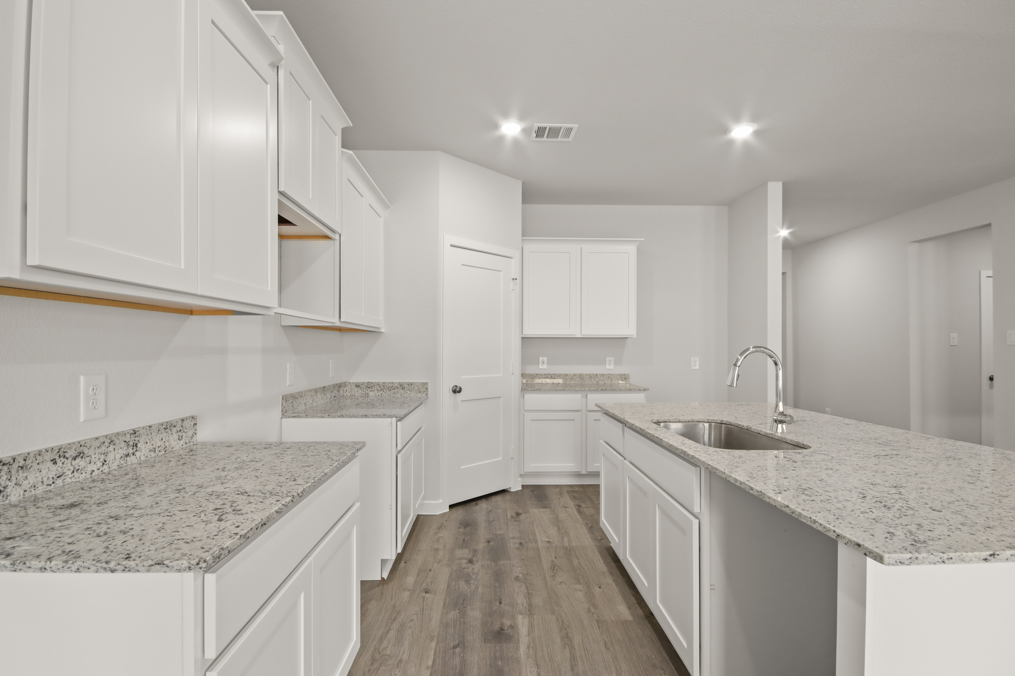 A kitchen with white cabinets.