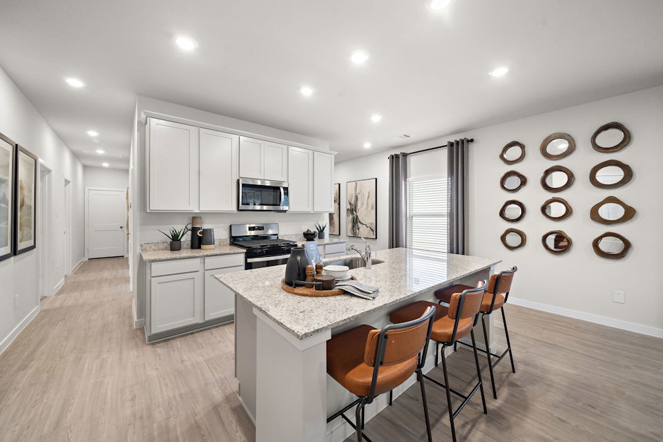 A kitchen with a dining table and chairs.