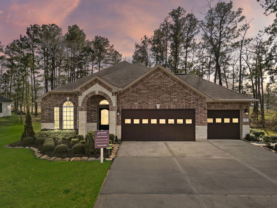 A house with a driveway and a sign in front of it.