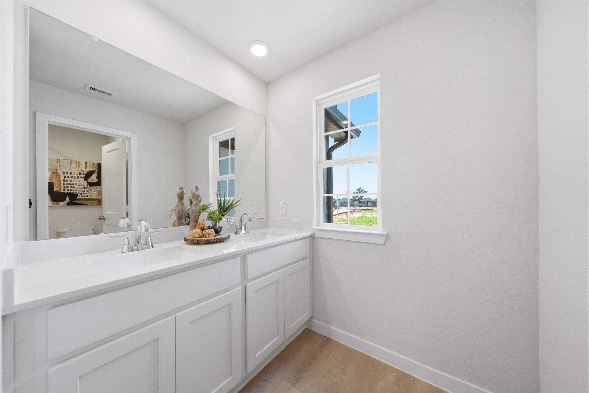 A bathroom with white cabinets.
