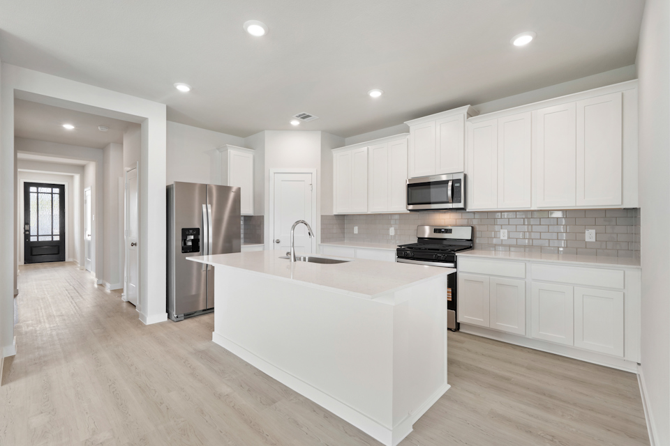 A kitchen with white cabinets.