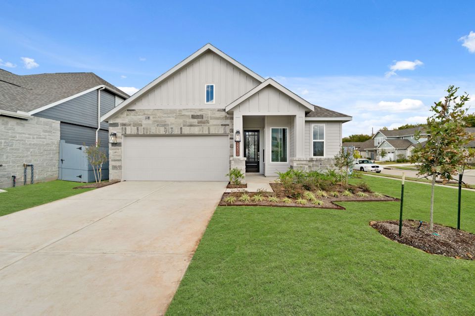 A house with a driveway with Southfork Ranch in the background.