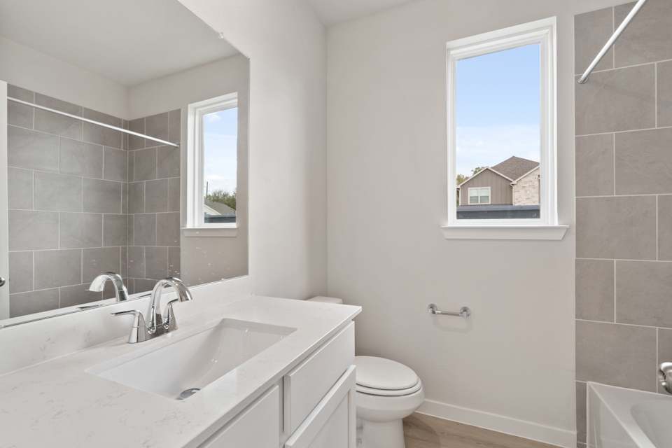 A bathroom with a tub sink and toilet.