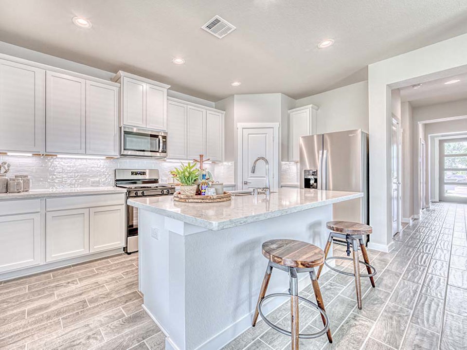 A kitchen with white cabinets.