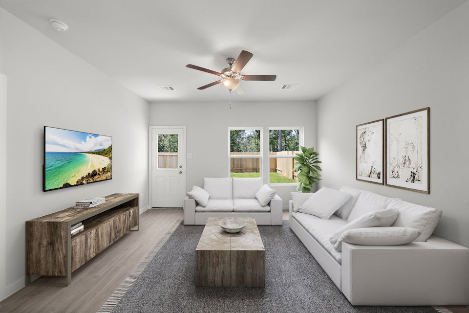 A living room with a white couch and a wood coffee table.