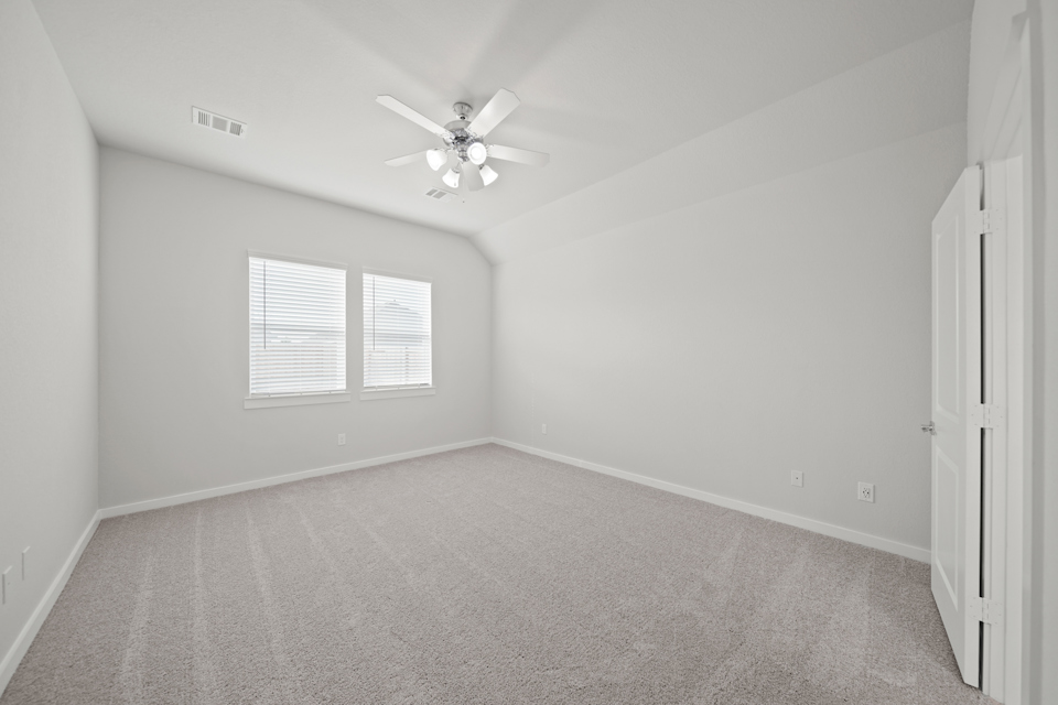 A room with a ceiling fan and a window.