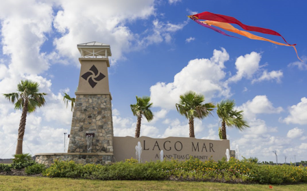 A sign with a kite flying over it.