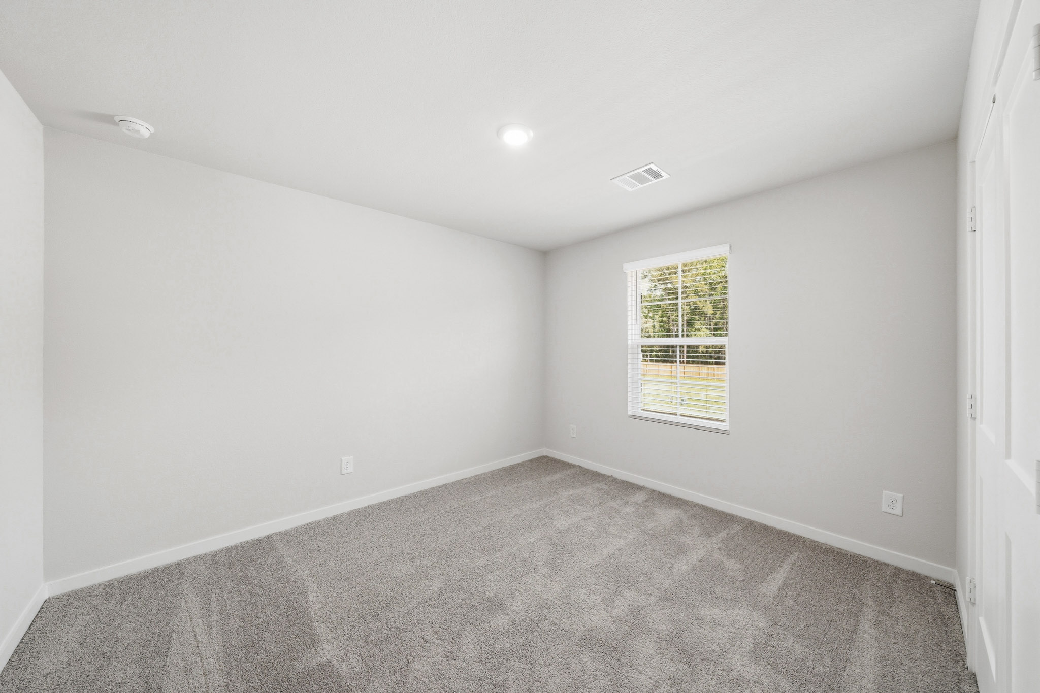 A room with a window and a carpet.