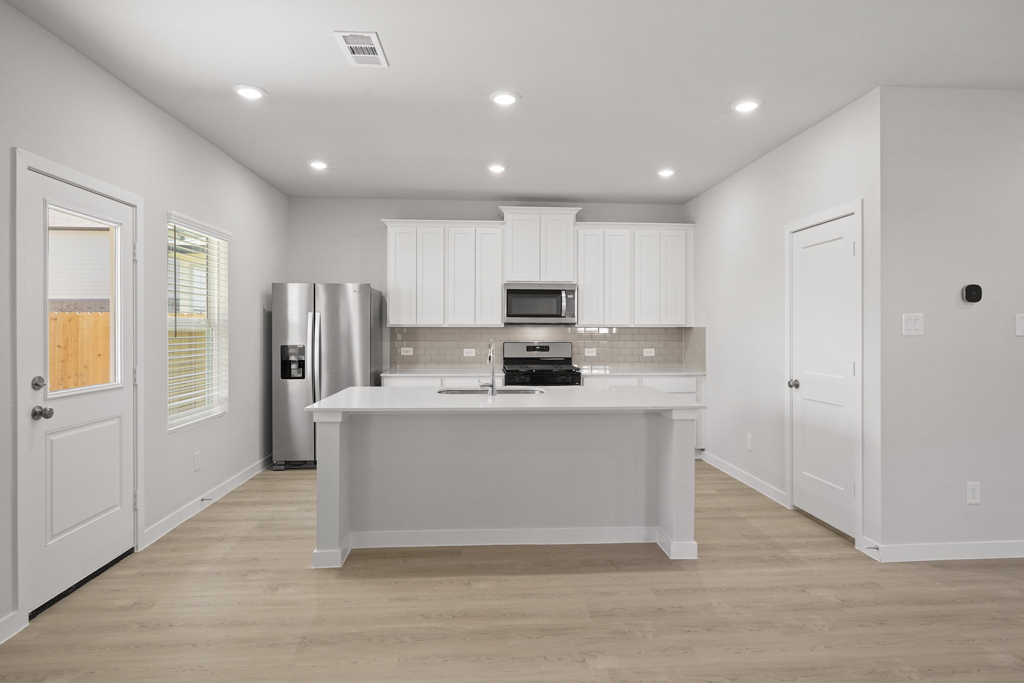 A kitchen with white cabinets.
