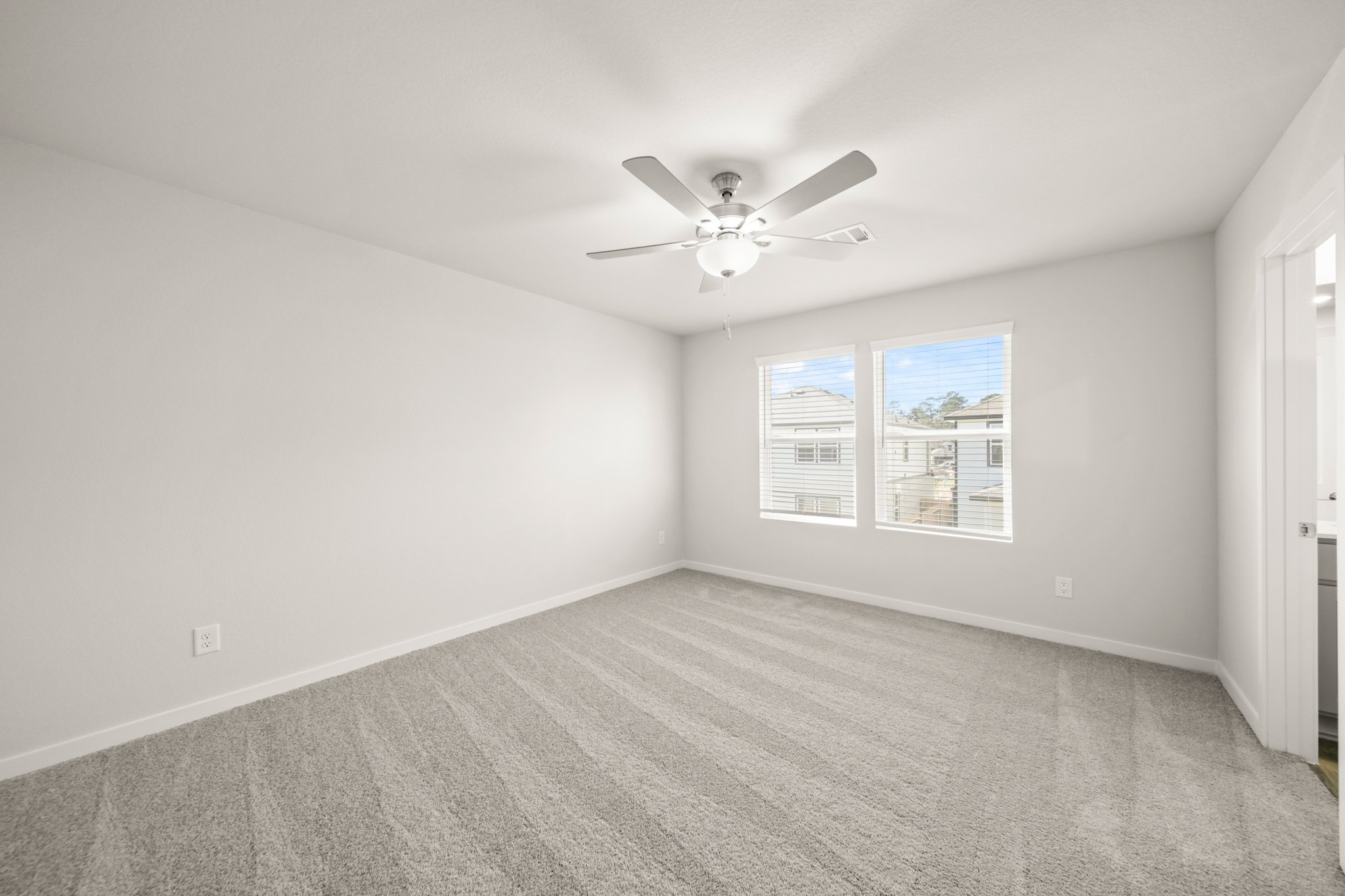A room with a ceiling fan and a window.