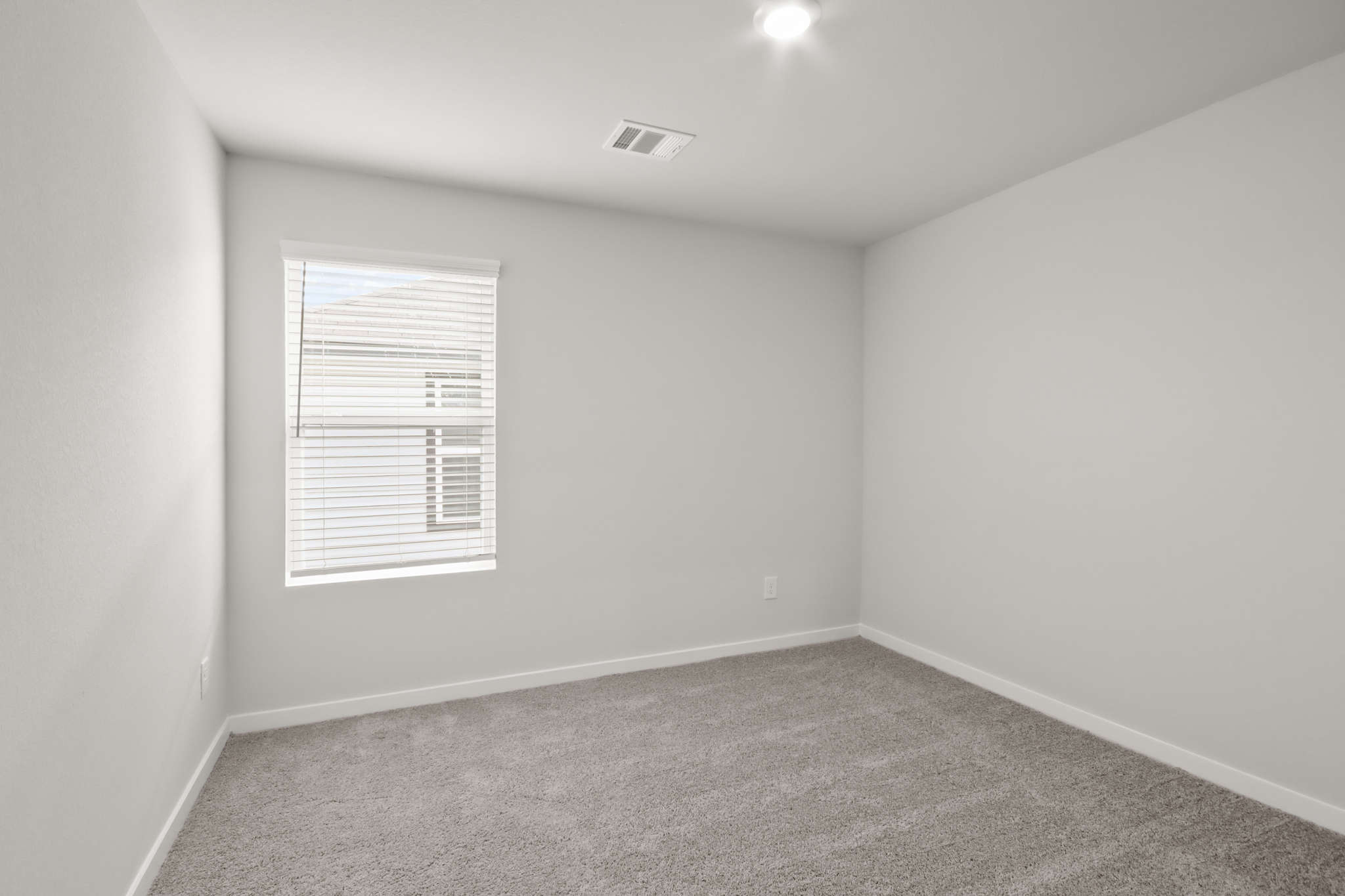 A room with a window and a carpet.