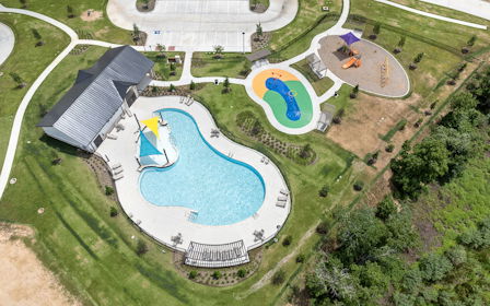 A building with a pool in the middle of a field.