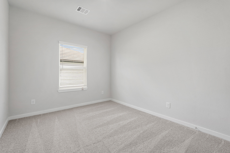 A room with a window and carpet.