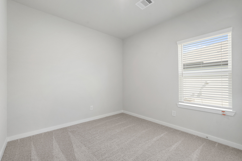 A room with a window and a carpet.