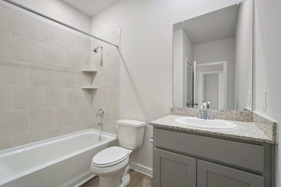 A bathroom with a tub sink and toilet.