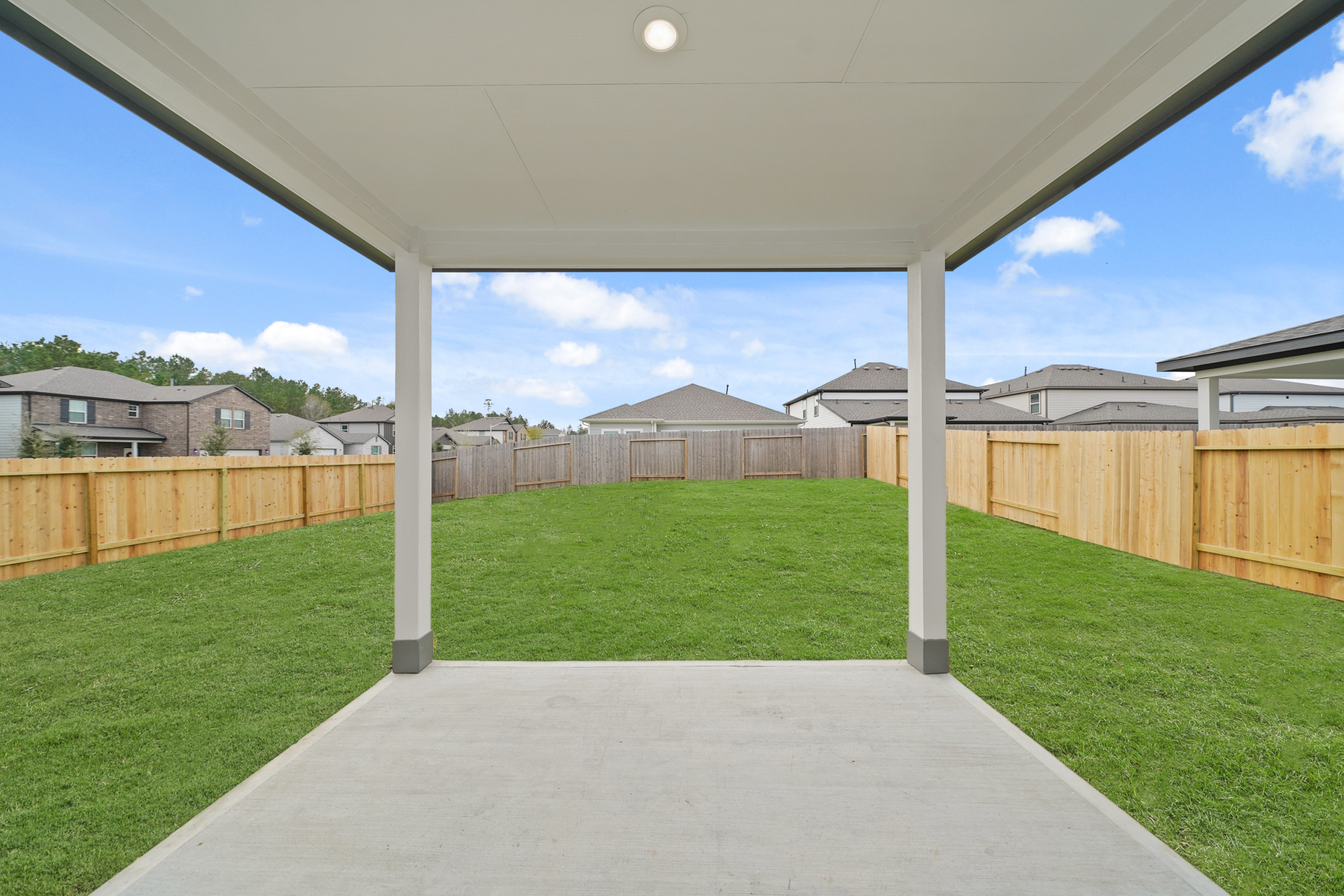 A backyard with a covered patio.