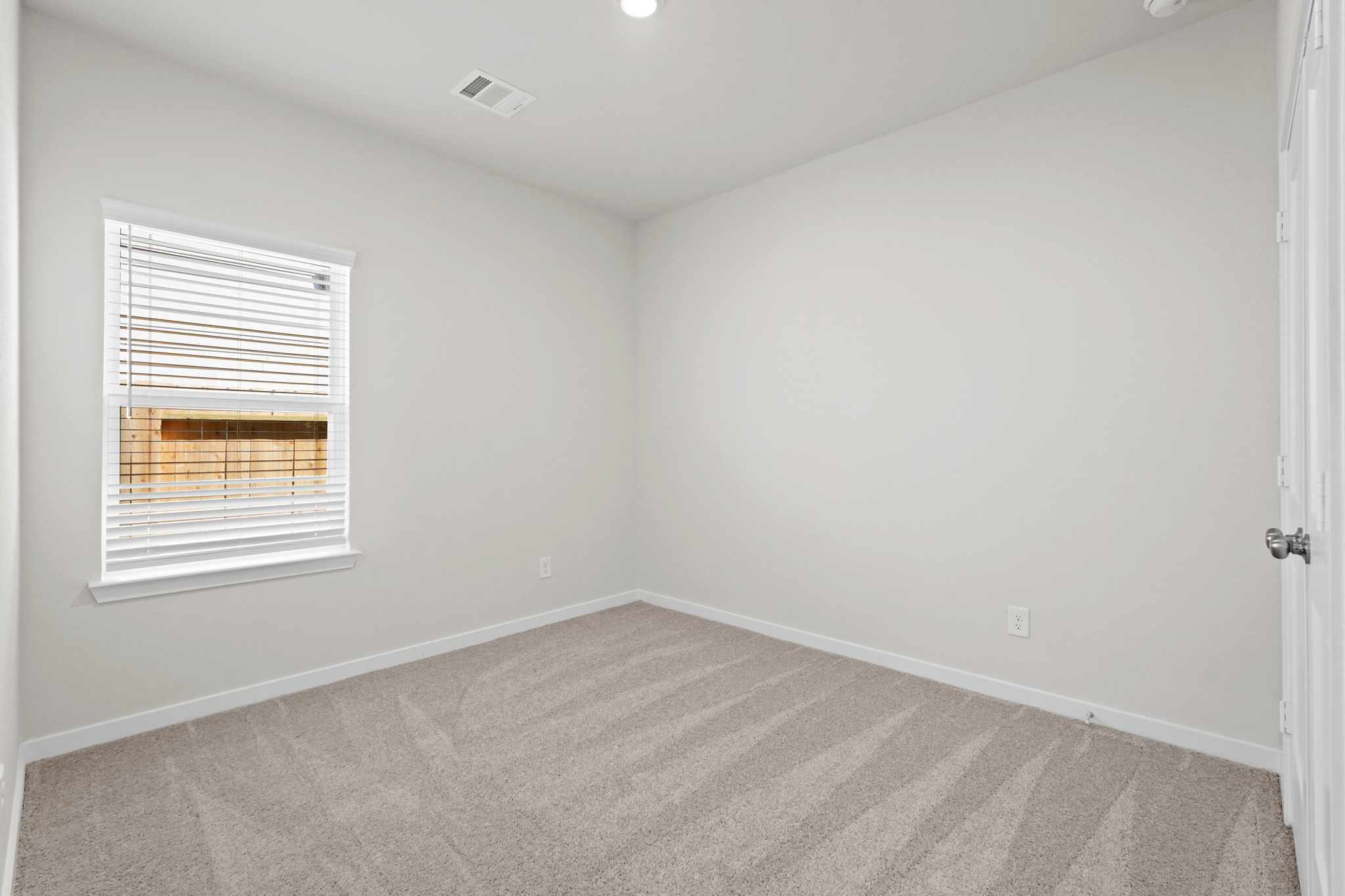 A room with a window and a carpet.