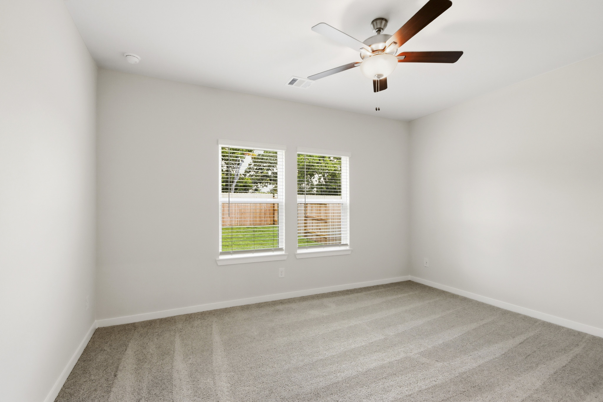 A room with a ceiling fan and a window.