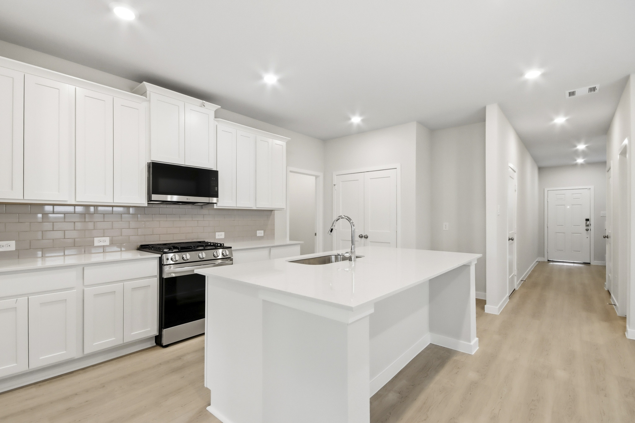 A kitchen with white cabinets.