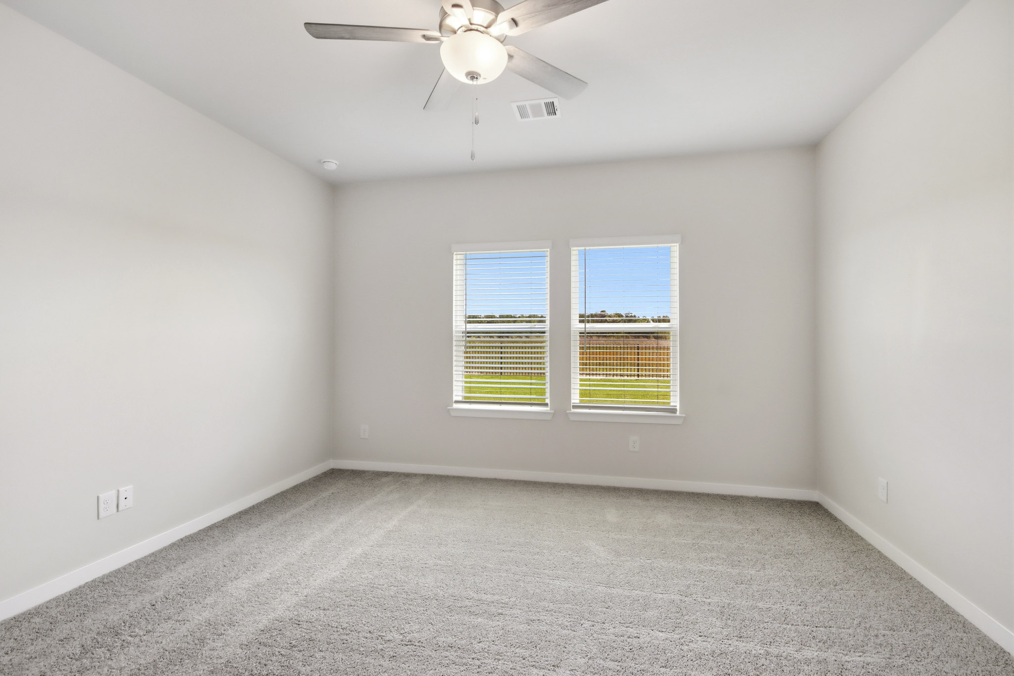 A room with a ceiling fan and a window.