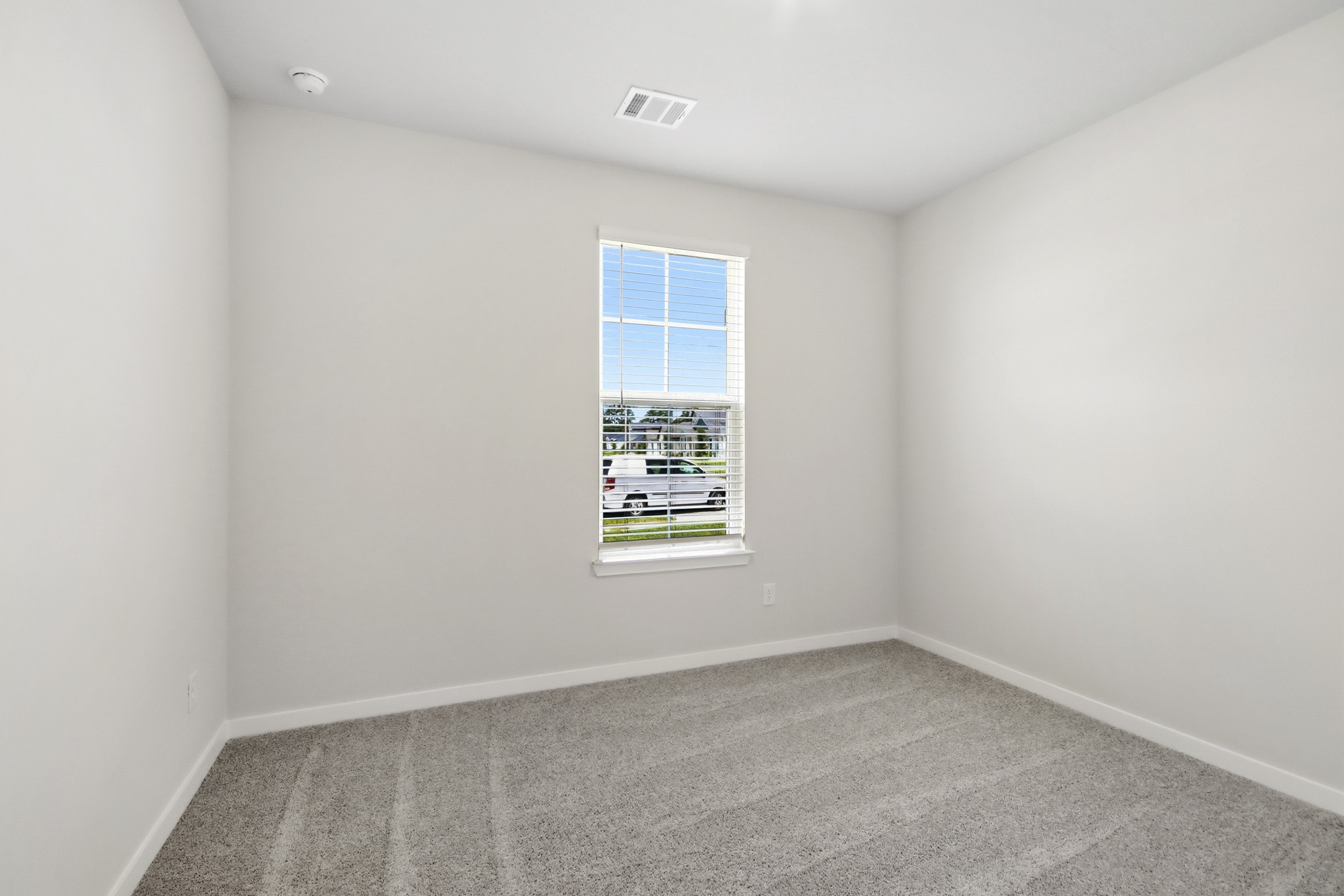 A room with a window and a carpet.