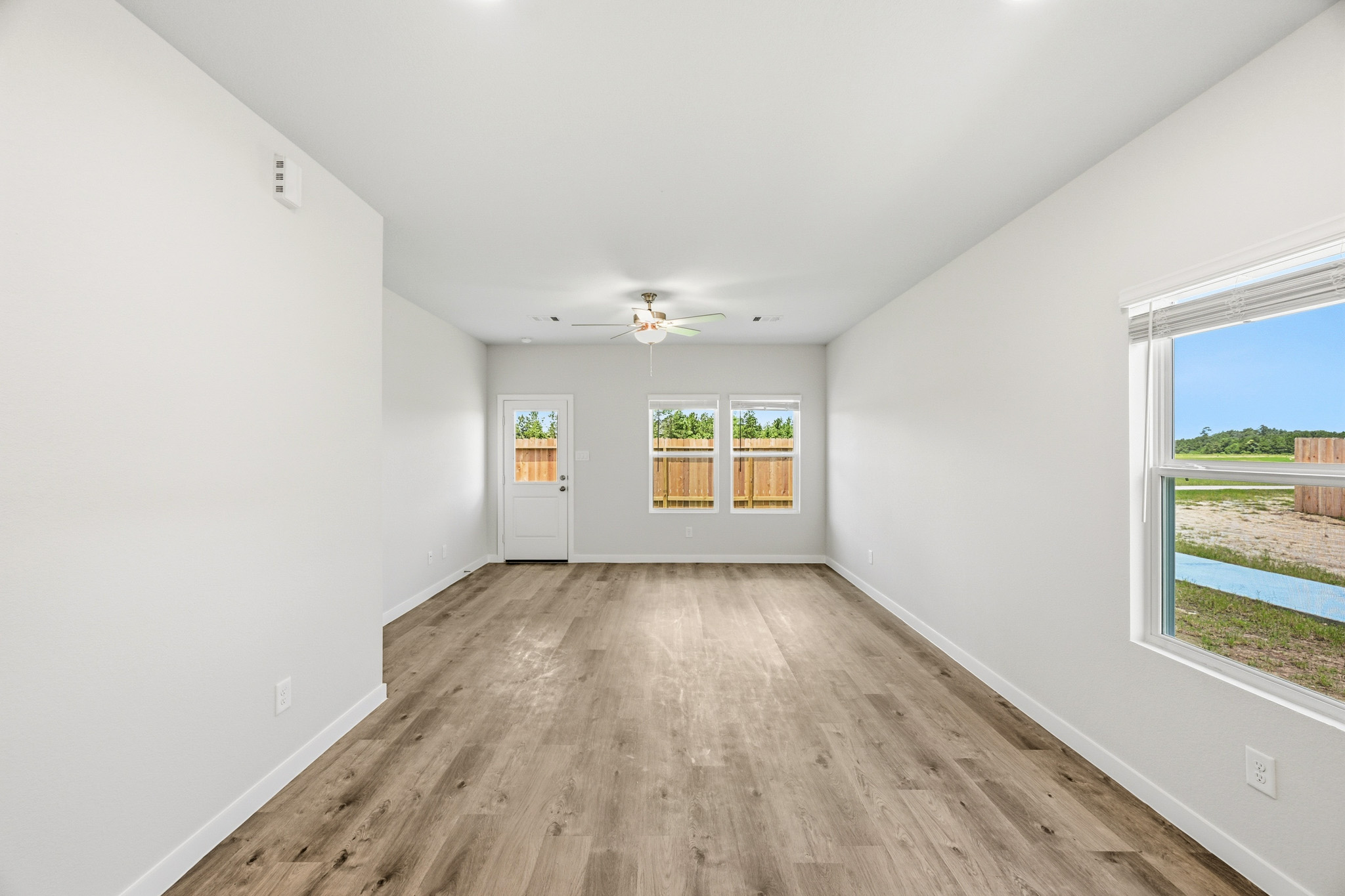 A room with a wood floor and windows.