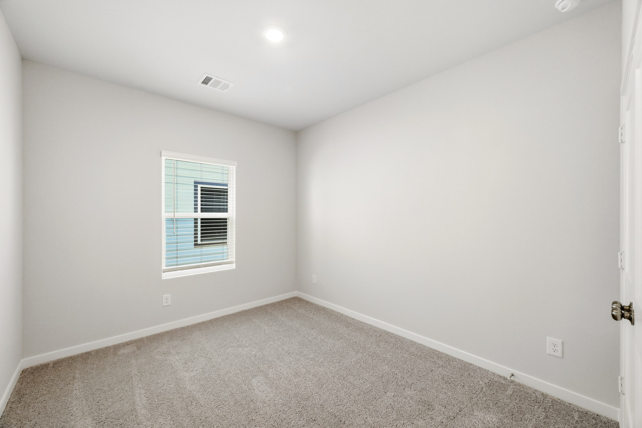 A room with a window and a carpet.