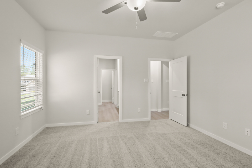 A room with white walls and a ceiling fan.