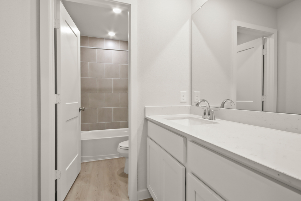 A bathroom with a tub sink and toilet.