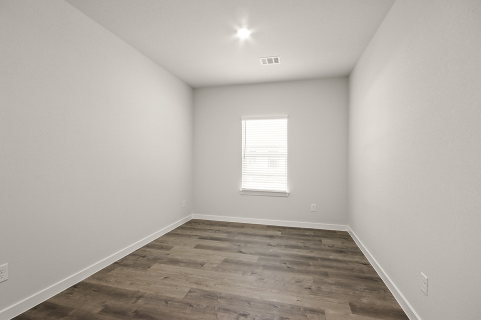 A room with a wood floor and a window.