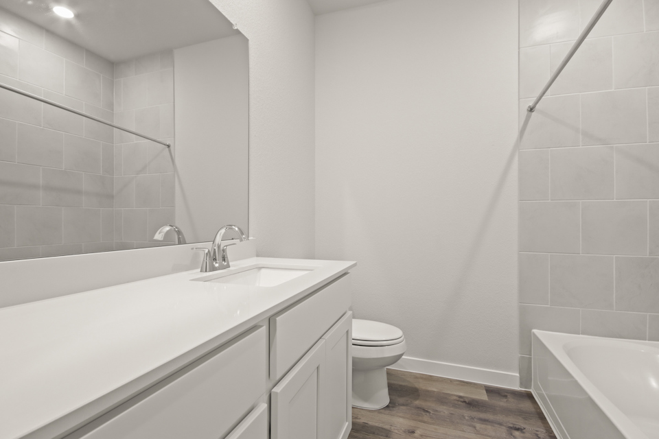 A bathroom with a tub sink and toilet.