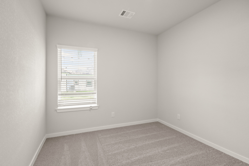 A room with a window and a carpet.