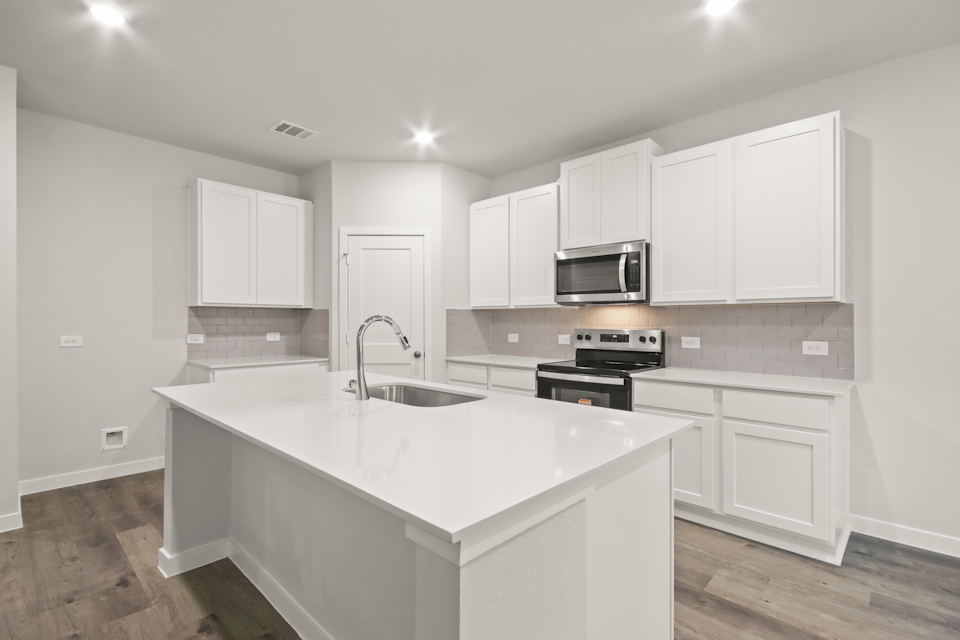 A kitchen with white cabinets.