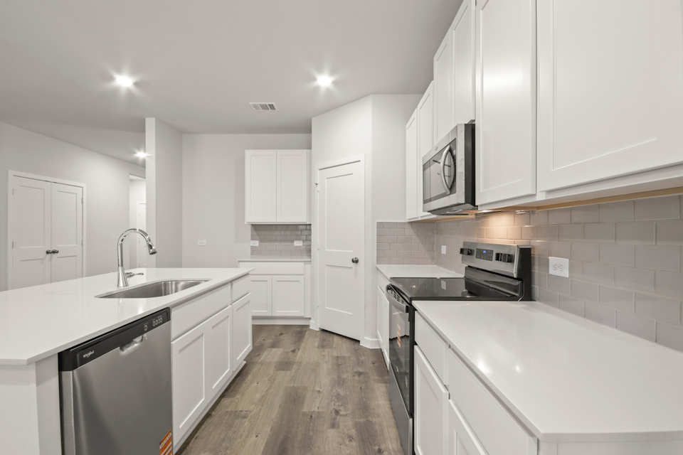 A kitchen with white cabinets.