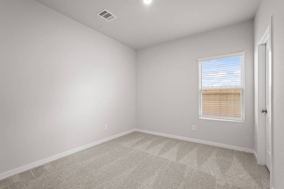 A room with a carpet and a window.