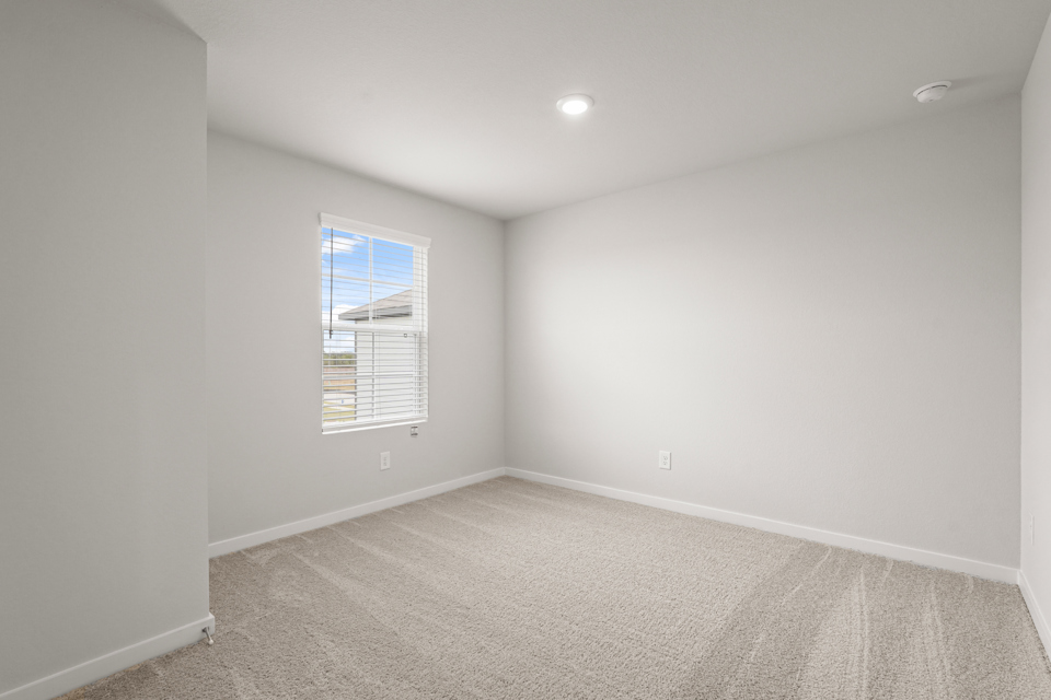 A room with a window and a carpet.