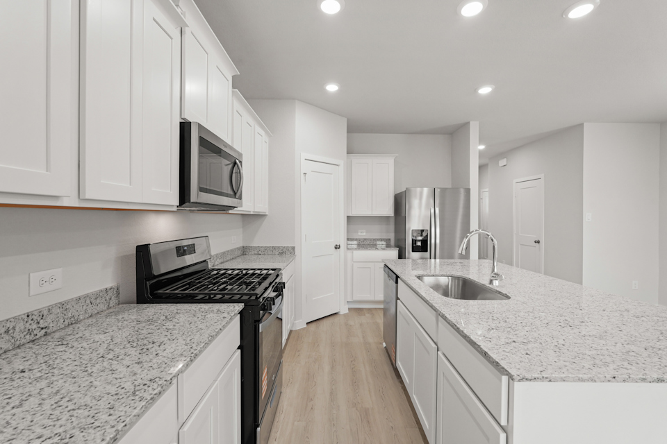 A kitchen with white cabinets.