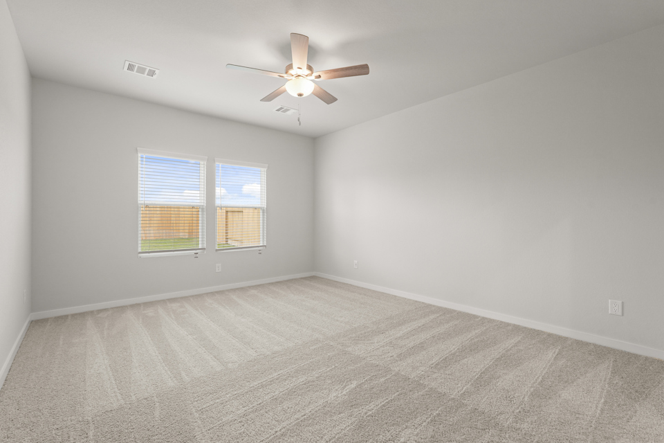 A room with a ceiling fan and a window.