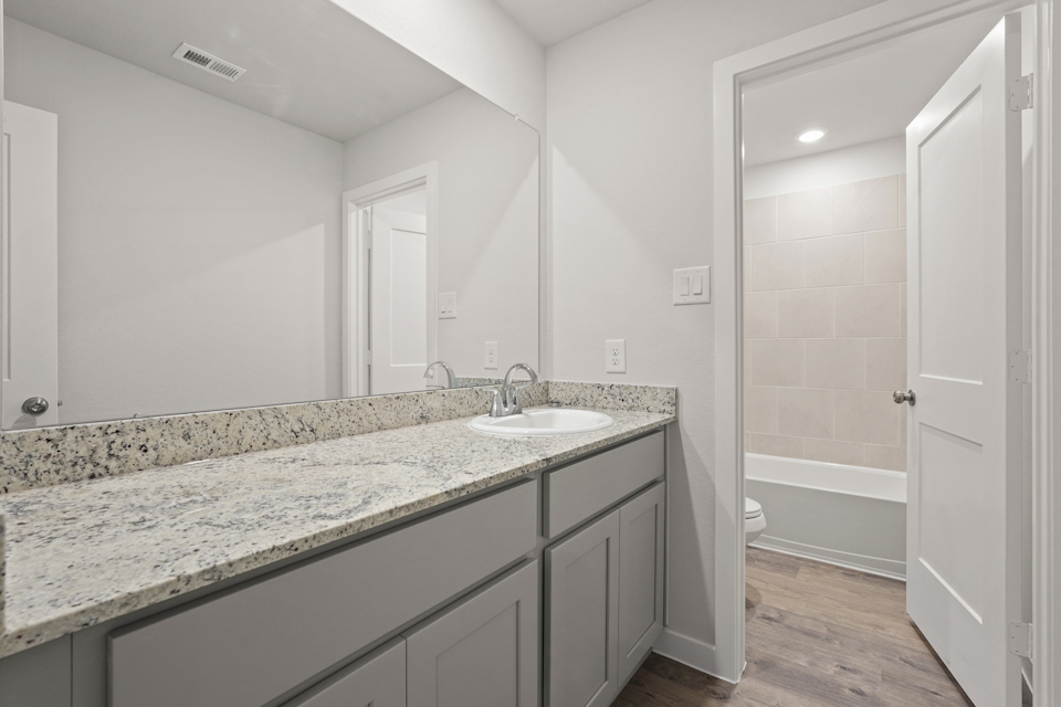A bathroom with marble countertop.