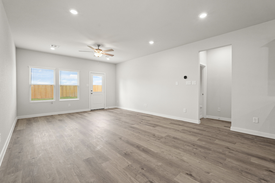 A room with a wood floor and a ceiling fan.