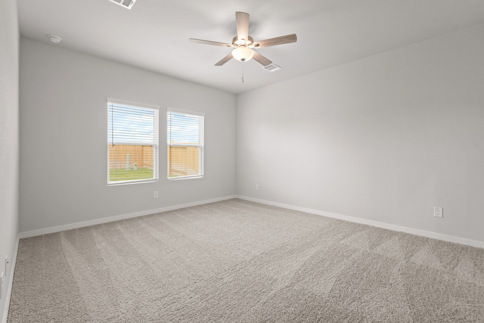 A room with a ceiling fan and a window.