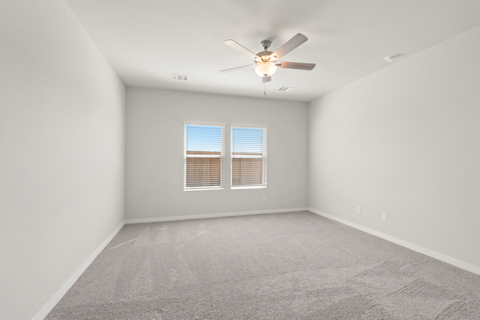 A room with a ceiling fan and a window.
