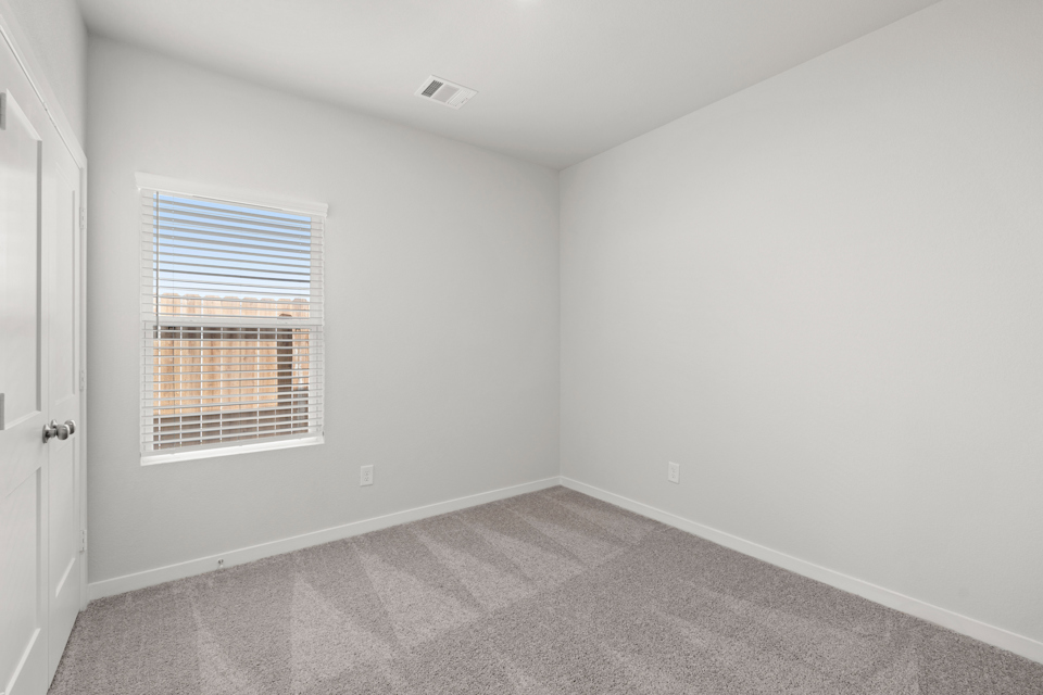 A room with a window and a carpet.