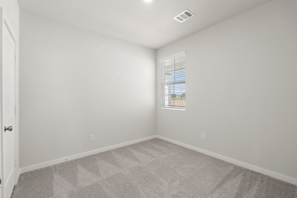A room with a window and carpet.