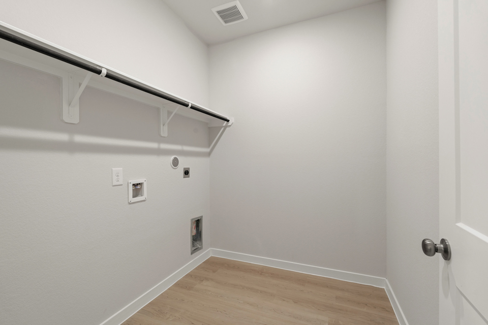A white room with a wood floor and white walls.