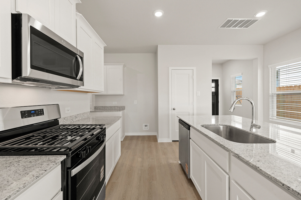 A kitchen with white cabinets.