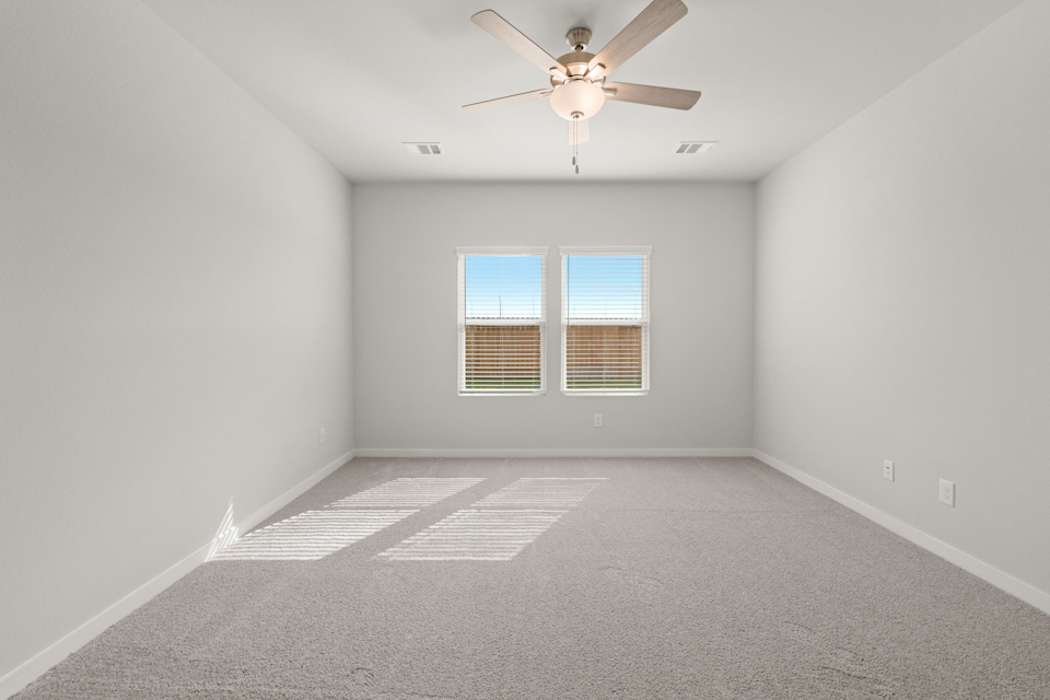 A room with a ceiling fan and a window.